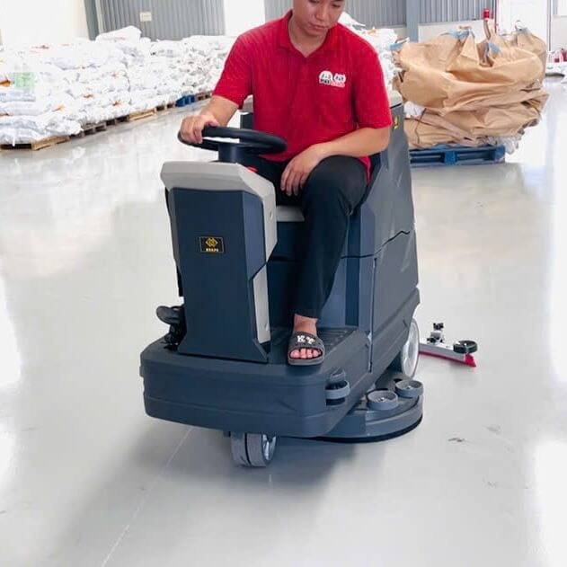 Máy chà sàn ngồi lái Krapo M2913 Máy chà sàn tự động M2913 đang hút nước bẩn, để lại sàn khô sạch.
